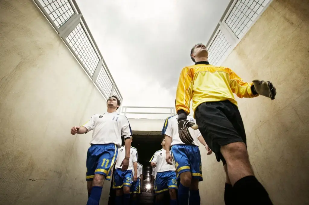 Jogadores a entrar em campo simbolizando futuro e evolução na carreira