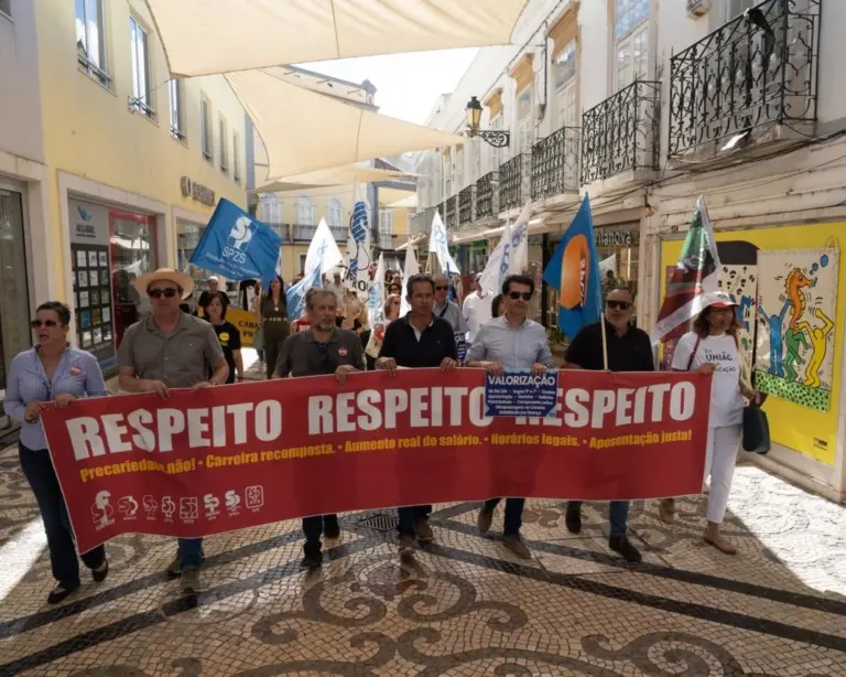 Multidão de trabalhadores e sindicatos em manifestação organizada no 1º de Maio em Faro com bandeiras e cartazes