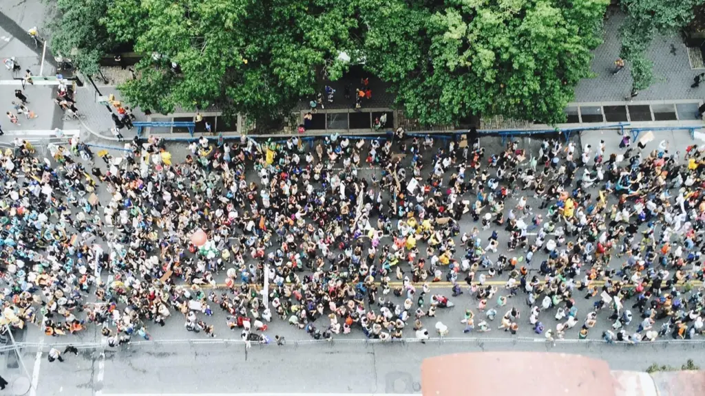 Manifestantes a marchar numa rua em perspetiva representando continuidade e evolução do movimento laboral